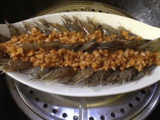 6、蒜蓉粉丝开片虾 ,将调好味的蒜蓉(连油)均匀的铺于虾上;