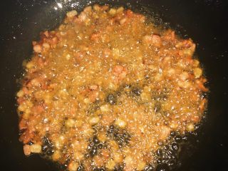 4、冯妈妈腊肉炫彩土豆泥,油入锅，油热倒入切好的腊肉颗粒翻炒