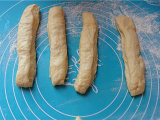 5、自制健康油条,操作台面上撒少许面粉，将静置好的面团用手轻轻按扁，分成宽10厘米，厚0,5厘米的面皮。