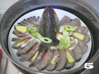 5、14图轻松打造节日餐桌家宴菜——【开屏鲈鱼】,将码好的鱼肉撒盐、放入葱片和姜片，冷水入蒸锅，上汽后大火蒸8分钟。