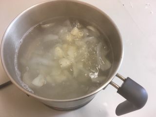 6、莲子百合海底椰甜品,把百合加入锅中。