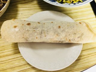 46、老北京春饼,双手慢慢的将薄饼卷起，裹紧！