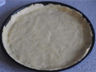 11、清甜水果派,擀好的派皮铺在派盘上，轻轻按压，扎些小孔，将派馅填入，弄平整