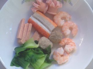 1、虾仁乌冬面（海鲜类）,备料：把火腿肠，鱼丸，菜，虾，切条的午餐肉，烫熟。备用！