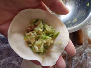 7、西葫芦饺子#健康美颜餐#,拿一个小剂子杆成皮,包入西葫芦陷用手捏好即可