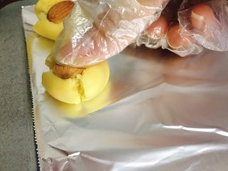 12、杏仁玛格丽特 (香浓酥松得掉渣哟),铝箔纸磨砂面朝上，饼干球放上杏仁，如图一样，稍微用力压下。