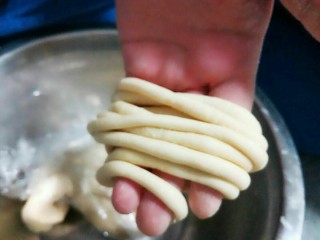 8、馓子,把醒好的面团搓成筷子粗的长条状。尽可能的搓细一点,如果不好搓手上就弄一点点温水,有助于搓成长条。