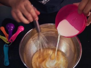 3、哆啦A梦铜锣烧,加入牛奶，继续搅拌均匀；