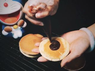 17、哆啦A梦铜锣烧,将豆沙围圈均匀挤到其中一个背面；