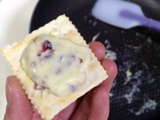 11、牛轧糖夹心苏打饼干,待牛轧糖温热时，右手套上一次性手套取一小团牛轧糖放在苏打饼干上。