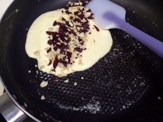 9、牛轧糖夹心苏打饼干,迅速加入切好的蔓越莓干和花生碎。