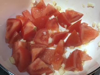 3、「吃货久久」香气扑鼻的番茄蛋花汤,锅内中小火 倒入大蒜番茄一起翻炒