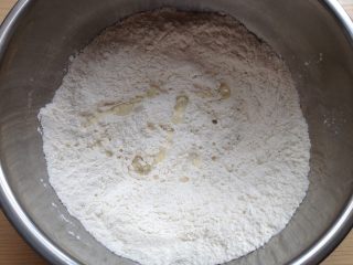 6、糖三角,先将化开的碱水倒入面粉中，跟着倒入温水和面