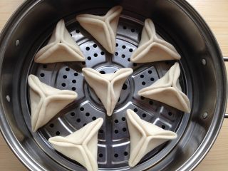 15、糖三角,锅中倒入冷水，笼屉刷油，把包好的糖三角生坯放进锅中（之间要有间隙），盖上锅盖，再次饧15分钟左右（冬天大概需要30分钟）