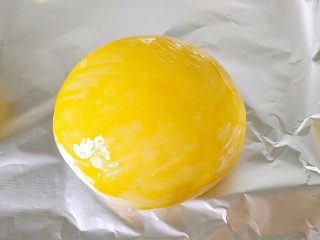 10、家庭版―汉堡包,二次发酵好的小面苤移到锡纸上，你也可以放在锡纸上进行二次发酵，也可以用油纸，再刷上全蛋液