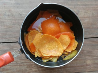 4、糖渍橙皮丁,放入奶锅，加入清水（配方外），燃气灶先开大火煮开，然后转小火煮10分钟左右，主要是为了去除橙皮的苦涩味