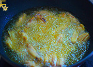 6、辣香鸡翅,转大火将油升温，当锅中保持平静开始冒清烟时将鸡翅集体入锅，保持大火炸至10-20秒后捞起