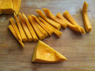 5、金瓜黑米饭,再从每小块两侧切下5~6毫米宽的南瓜条，大约切十几条备用；