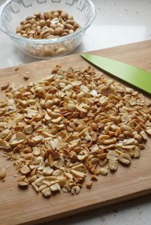 2、粗粮摇身变娇软小蛋糕,晾凉后的花生米,搓掉红皮,然后用刀切碎。