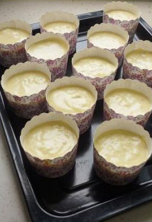 11、粗粮摇身变娇软小蛋糕,将混合糊倒入小蛋糕纸杯中,八分满即可。