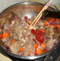 3、红酒炖牛肉,加面粉拌匀，加盐、胡椒粉、蒜粒、番茄酱、红酒煮开后倒入化好的高汤