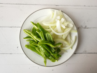 3、【干煸土豆片】 ,将尖椒和洋葱切成条