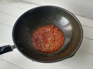 7、【干煸土豆片】 ,下入花椒小火炒制花椒微焦，将花椒捞出不要，再下入郫县豆瓣酱小火炒出红油，下入姜末、蒜片炒香