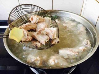 4、莲藕烧排骨（附无水无油炒糖色技巧）,大火煮开，煮约5分钟左右，捞出小肋排骨块备用。