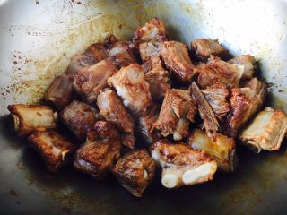 9、莲藕烧排骨（附无水无油炒糖色技巧）,倒入焯过水的小肋排迅速翻炒，让糖色均匀的裹在小肋排上。