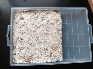 10、黑芝麻杏仁牛轧糖,戴上手套，可借助刮刀等工具，把牛轧糖趁温热抹平，整理好形状。