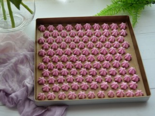 17、火龙果酸奶溶豆,均匀的挤在烤盘上。再放进预热好的烤箱中，上下管100度，烤60分钟。根据自己的烤箱调节温度。如果烤箱有热风模式，可以在最后十分钟的时候打开热风。