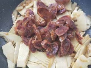 14、春笋炒腊肠,倒入腊肠。