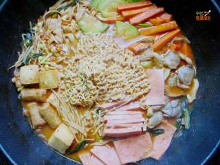 10、家庭版韩式部队火锅,水开后放入拉面,在拉面上放一片芝士,盖盖子,煮到拉面变软即可