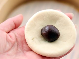 7、花样豆沙包,把面团摁扁加入豆沙馅