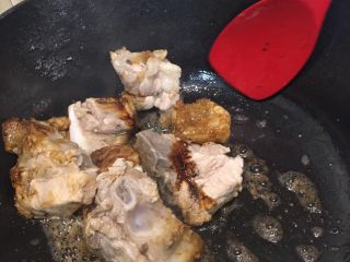 5、排骨烩菜,油锅烧热，放入排骨，加入料酒，老抽上色煸炒