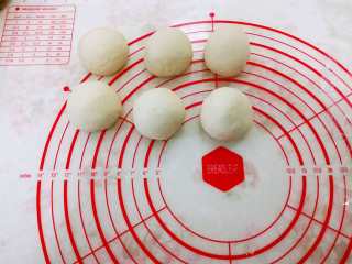 5、德式碱水包,把面团分成六份、每份68-70克左右的，搓圆盖上保鲜膜松弛30分钟。