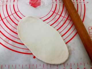 6、德式碱水包,30分钟之后，我们取一个松弛好的面团，擀开成图片形状。尽量往长了擀。