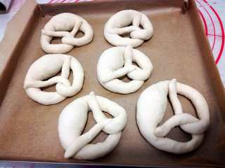 11、德式碱水包,把整形好的面团放在烤盘里，入冰箱冷冻至少两小时以上，时间长一点没关系，但是一定要保证冻成型。