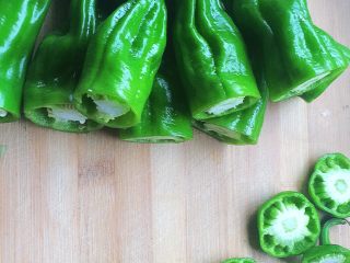 6、青椒塞肉（家庭版）,准备9个青椒，把青椒的粗的一头先切开。后面的尖的一头也可以少切掉一点。烧的时候更入味。