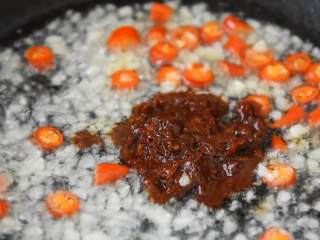 2、养生菜谱，红烧豆腐做法，汤汁浓郁好下饭,锅中热油，放入蒜末，小米椒爆香，加入豆瓣酱炒匀。