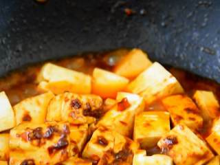 4、养生菜谱，红烧豆腐做法，汤汁浓郁好下饭,加少许清水，盖上锅盖焖煮2分钟。