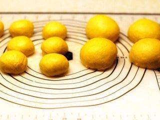 9、木糖醇椰子油南瓜面包,分割面团，排气滚圆，100克六个面团，40克8个面团，盖保鲜膜醒发20分钟。