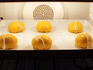 11、木糖醇椰子油南瓜面包,醒发好的六个各100克面团在次拍气滚圆，取四根棉线，十字交叉摆放，将面团轻放其上捆好依次放入烤盘，36度湿度70%二次发酵一小时。