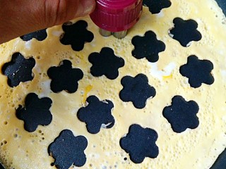 9、波点蛋包饭,取切花器或裱花嘴在蛋饼上盖出小花图案，取下的图案备用。