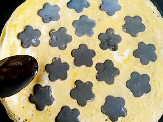 10、波点蛋包饭,小勺舀蛋清填满小花图案。开小火至蛋清凝固。