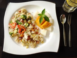 4、红肠洋葱暖心炒饭,蔬菜七分熟时迅速滴入剩余半勺橄榄油，加盐及酱油几滴上色增味，翻炒至蔬菜八分熟关火放葱花出锅装盘。用切好水果（芒果、白玉瓜）一起拼盘。