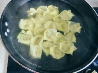 11、虾皮猪肉馄饨,接着下入馄饨，用锅铲在锅底慢慢推一下馄饨，避免馄饨粘锅底。