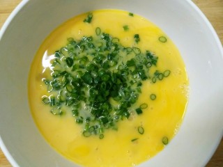 3、超人气的厚蛋烧，吃一次就上瘾,把葱末倒入鸡蛋液中，放少许盐搅拌均匀。