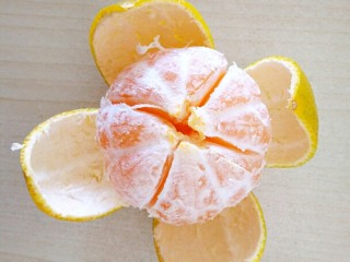 2、橘子罐头,用水果刀在外皮划十字，然后再慢慢剥开皮，小心刀不要切的太深，不要把果肉切破了。