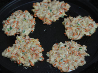 9、虾饼,用勺子舀一勺糊糊放进电饼铛里，用筷子将面糊弄平成饼状